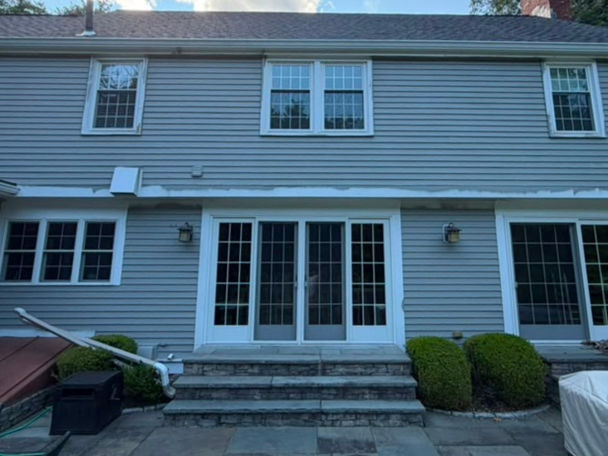 Rear exterior of a two-story home with gray horizontal siding and white trim